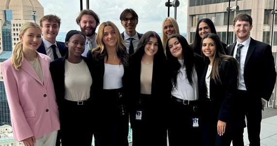 A group of PNC interns standing in a group smiling for a photo