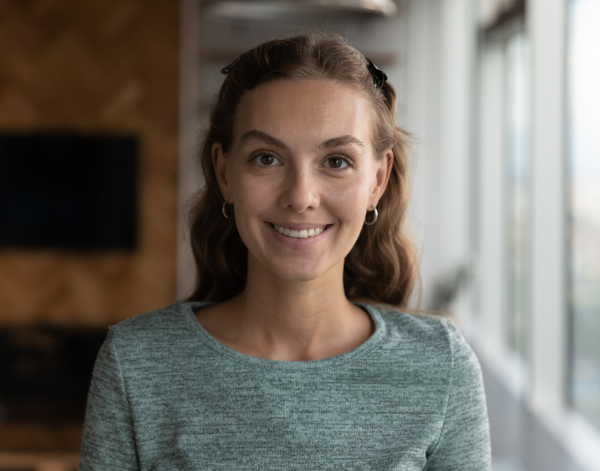 Headshot of a woman smiling with a blurred background.