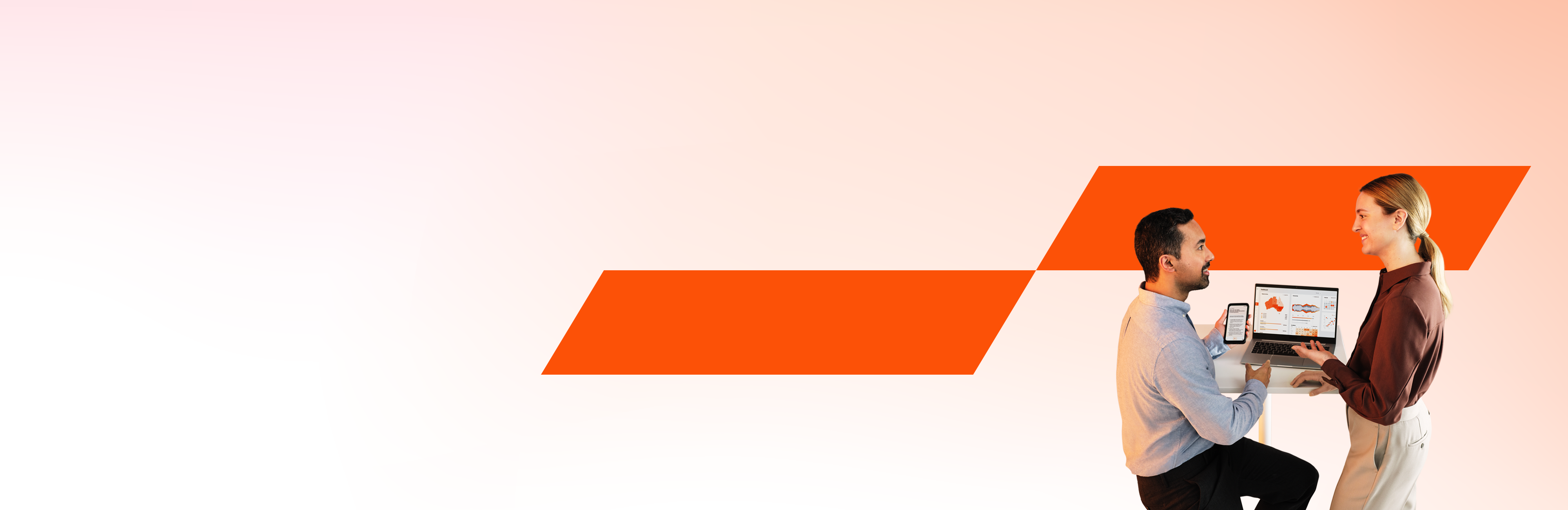 Zwei Kollegen blicken gemeinsam auf einen Laptop