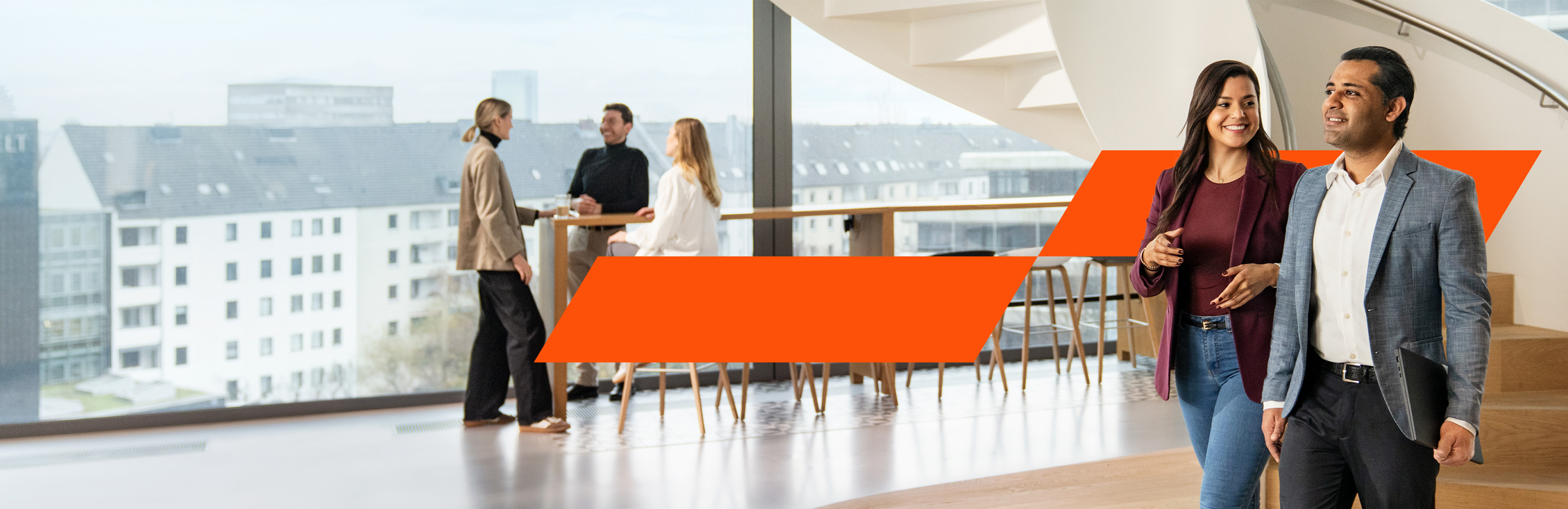 Zwei Kollegen laufen durch das Büro und unterhalten sich