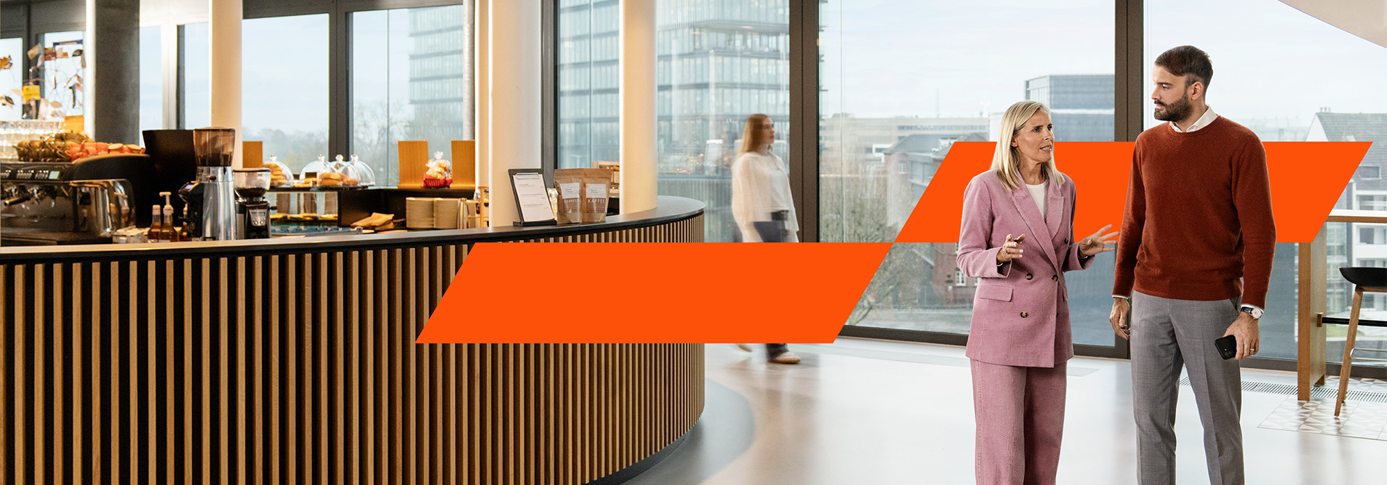 PwC Kollegen stehen im Büro und unterhalten sich