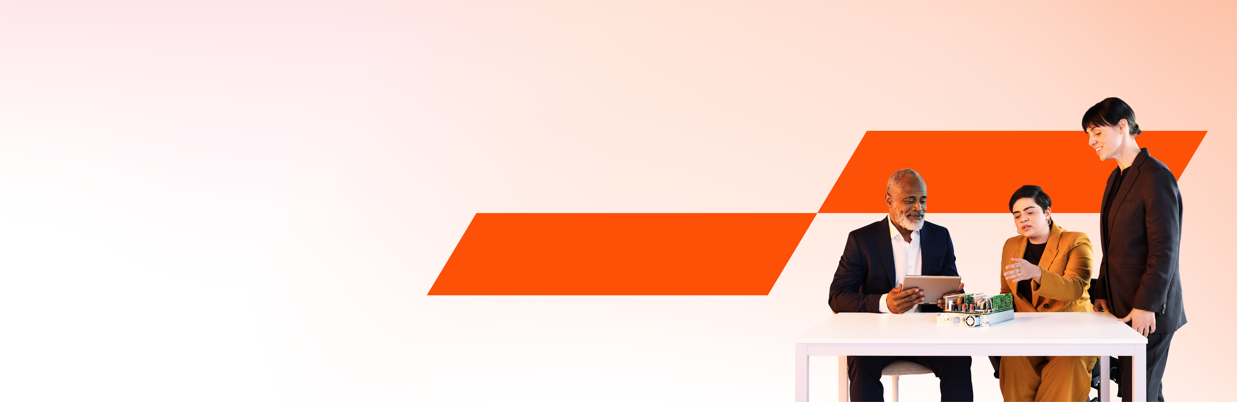 Ein Team aus drei Geschäftsleuten, die an einem Projekt auf einem elektronischen Gerät arbeiten.