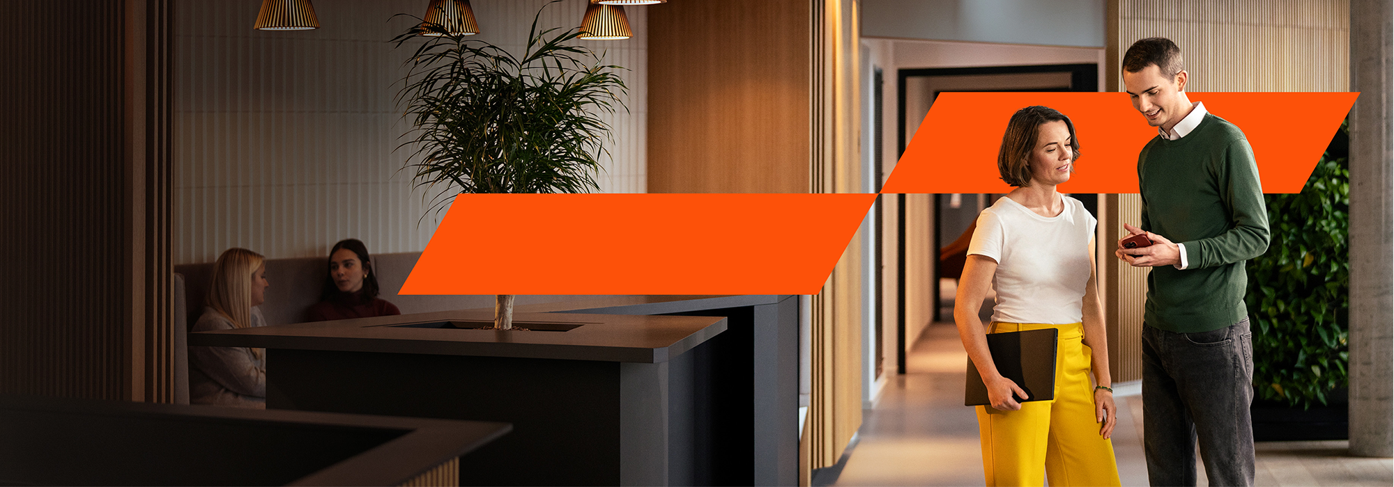 Zwei Kollegen stehen zusammen und blicken auf ein Smartphone