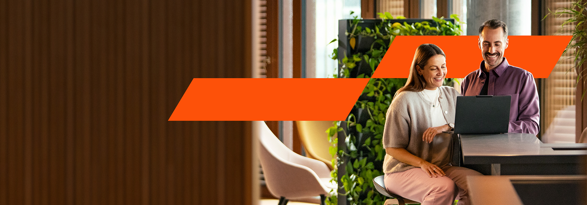 Zwei Personen blicken auf einen Laptop