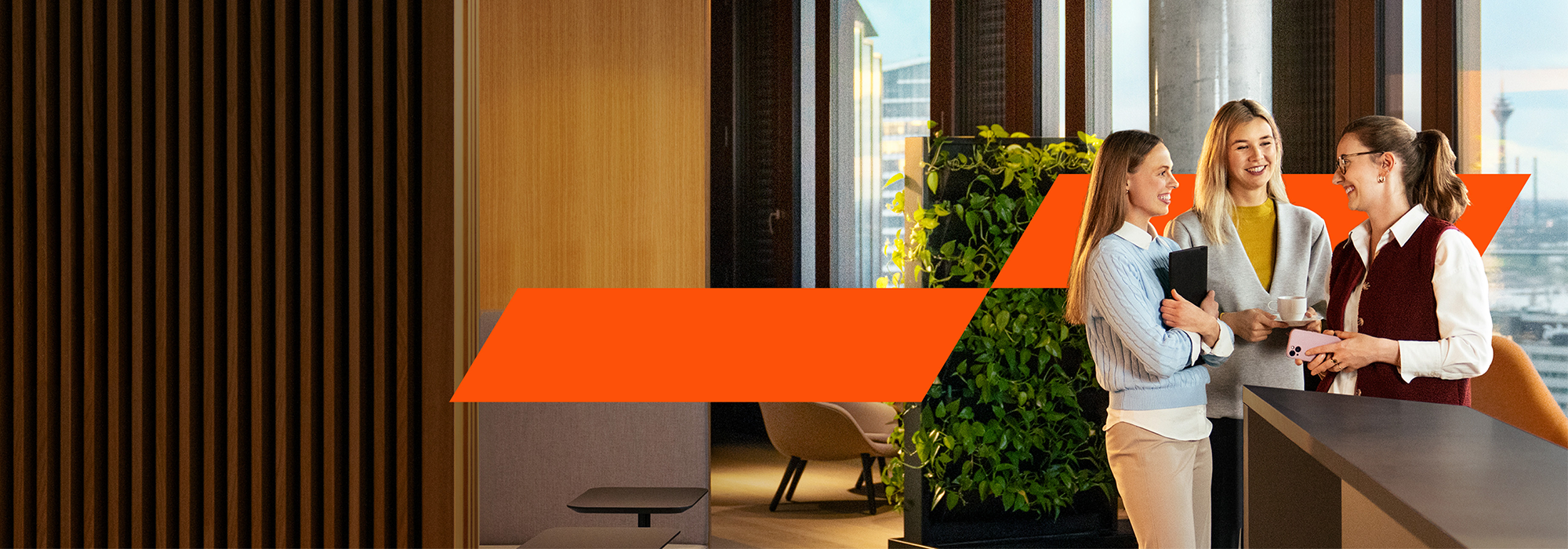 Ein Team aus drei Geschäftsleuten, die an einem Projekt auf einem elektronischen Gerät arbeiten.