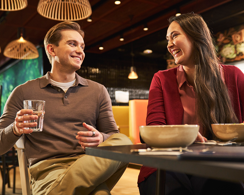 Zwei Kollegen essen gemeinsam und lachen
