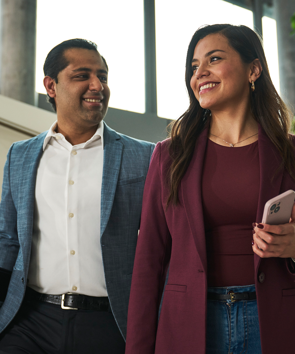 Zwei Kollegen laufen durch das Büro und unterhalten sich