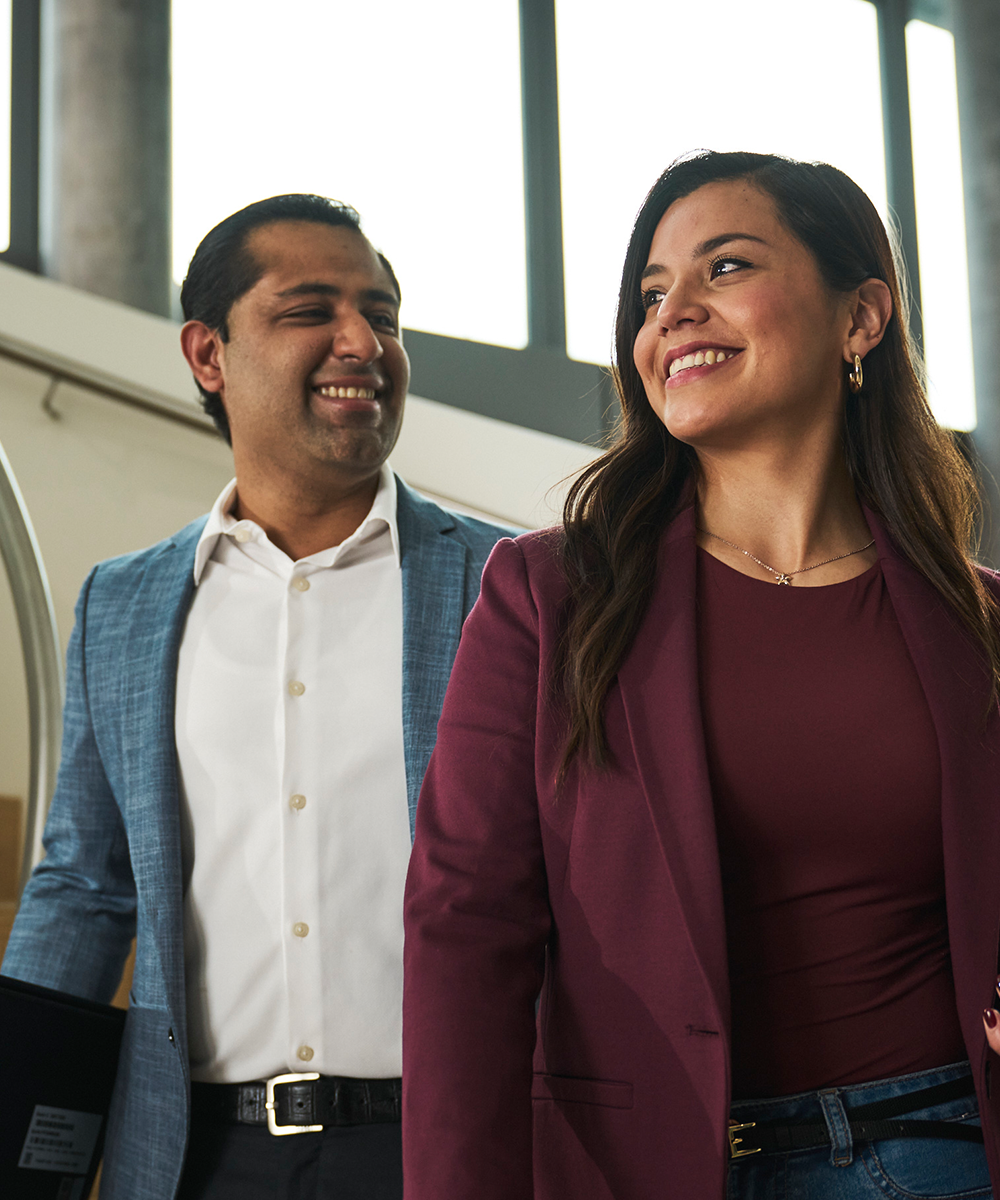 Colleagues walk together through the office