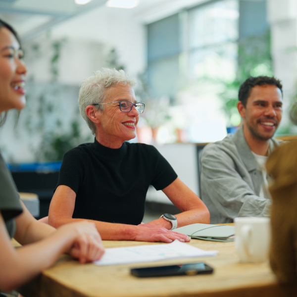 Grey haired lady at table with team