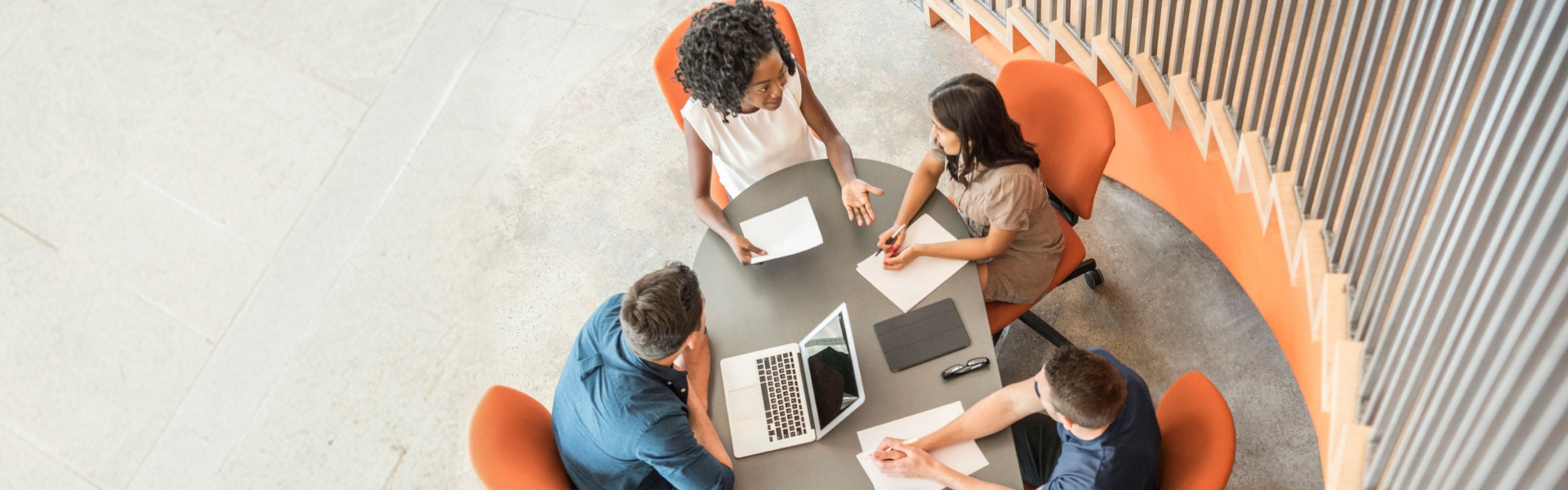 Group of young workers sitting around oval table