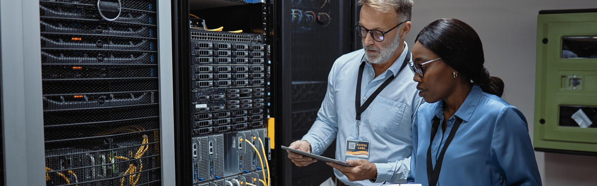 IT technicians using a digital tablet in a server room