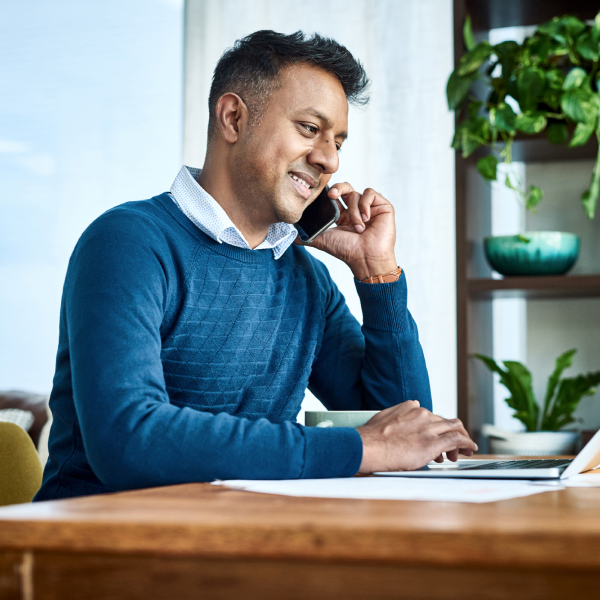 Man using a laptop and smartphone while working from home