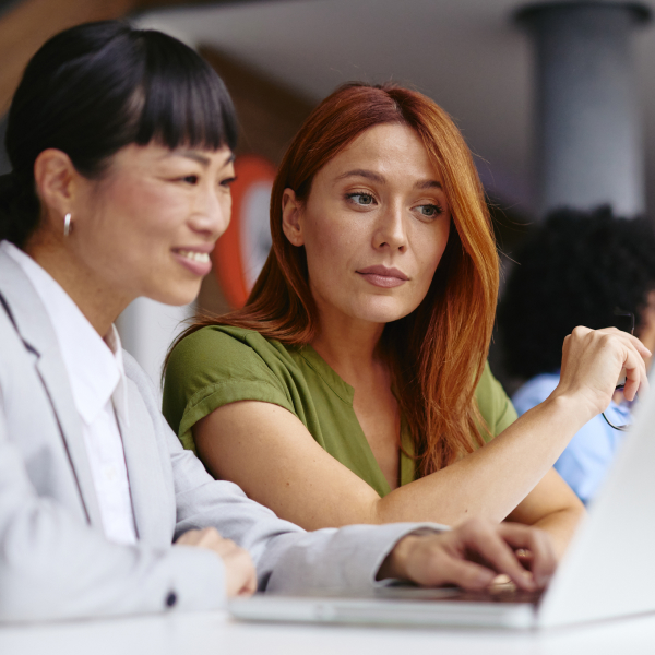 Professionals collaborate around a laptop in a modern office