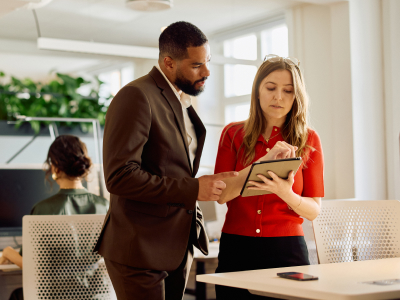 Two professionals focused on a tablet