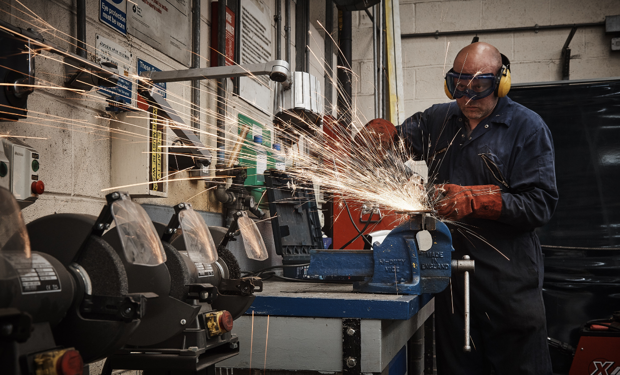 Mechanic wearing safety equipment working with machinery