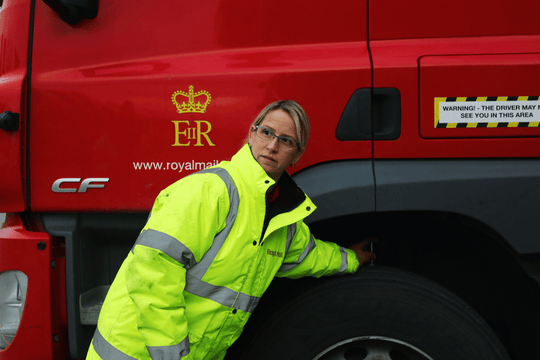 Vehicle driver checking tyres on lorry
