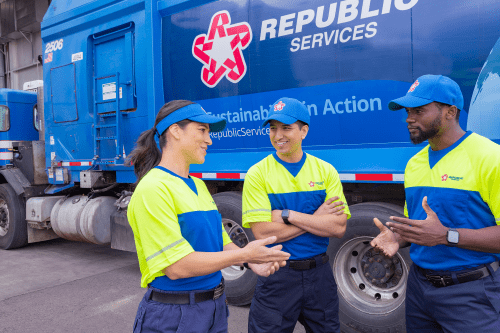 three employees speaking with a truck in the background