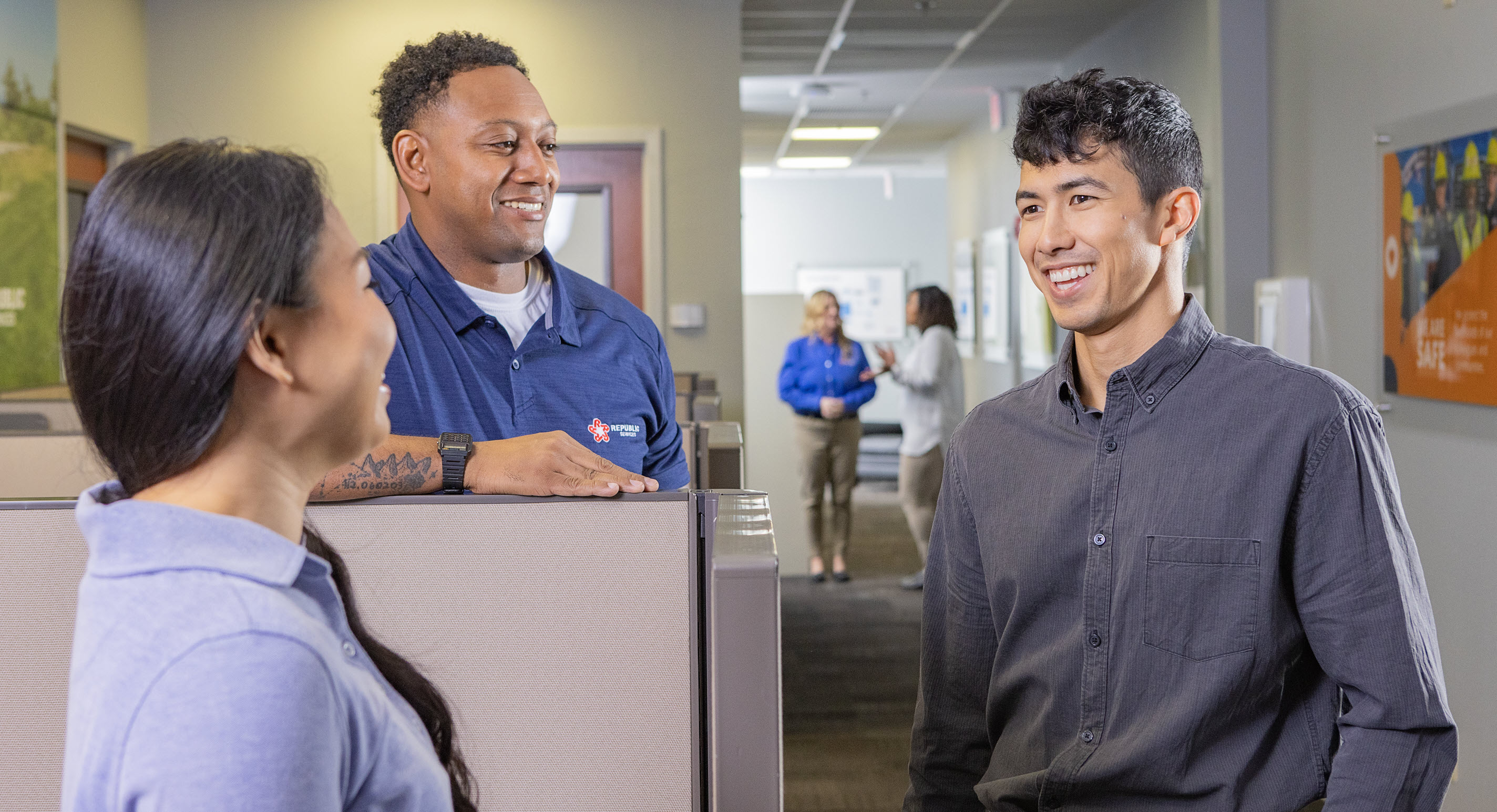 three coworkers in an office setting talking