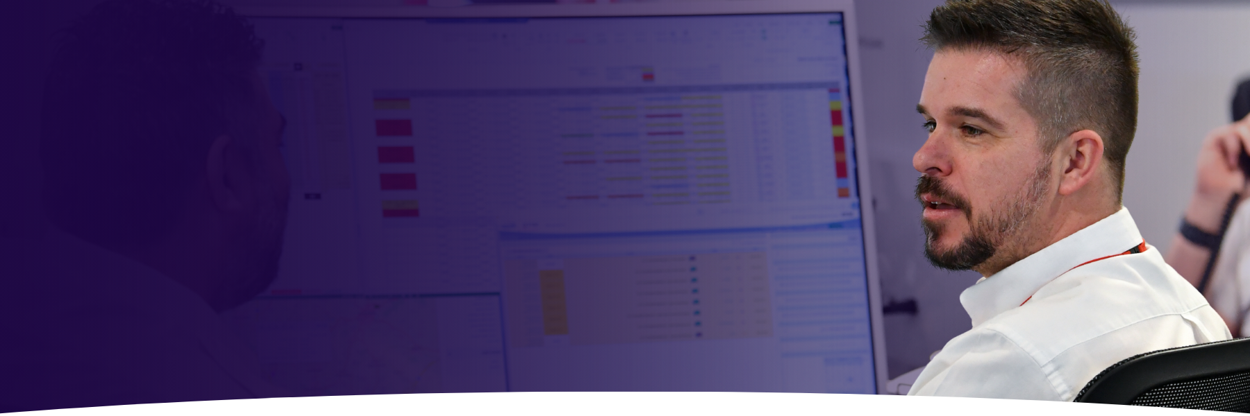 A man in a white shirt in a control centre room