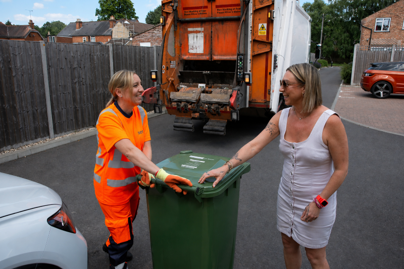 A refuse collection operative - or loader - interacting with a resident.