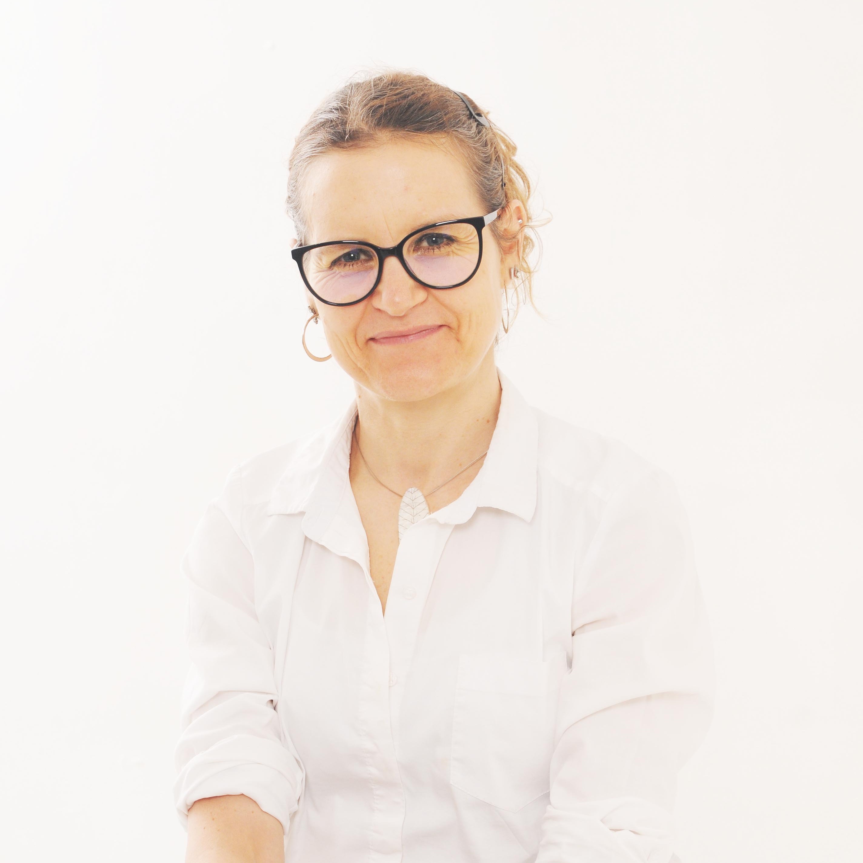 Woman wearing glasses and a white shirt