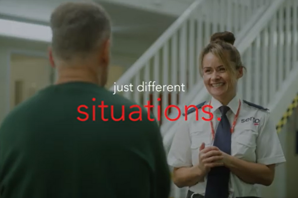 A woman in prison officer uniform smiling