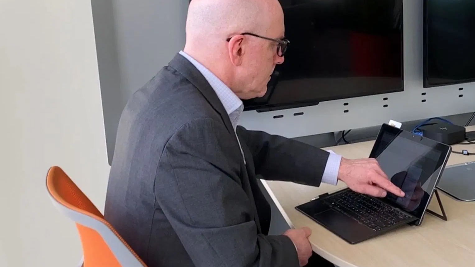 Jim Jacobson sitting at his desk working on a laptop