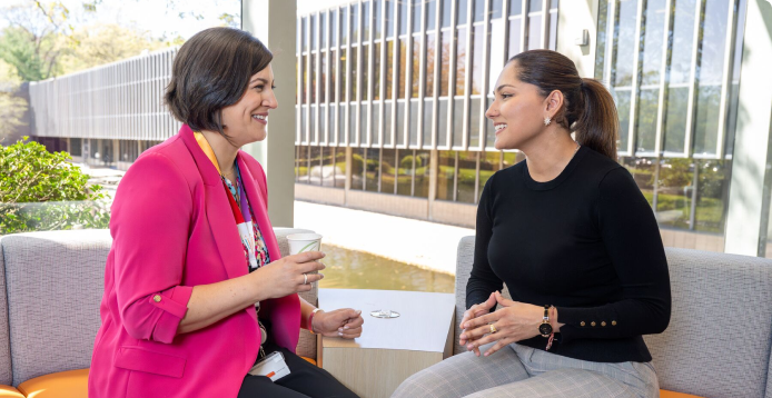 Two female Healthineers having a career growth conversation while sitting in an office lounge area