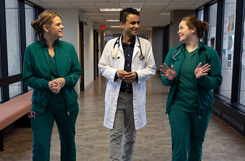 Nurses walking hallway with physician