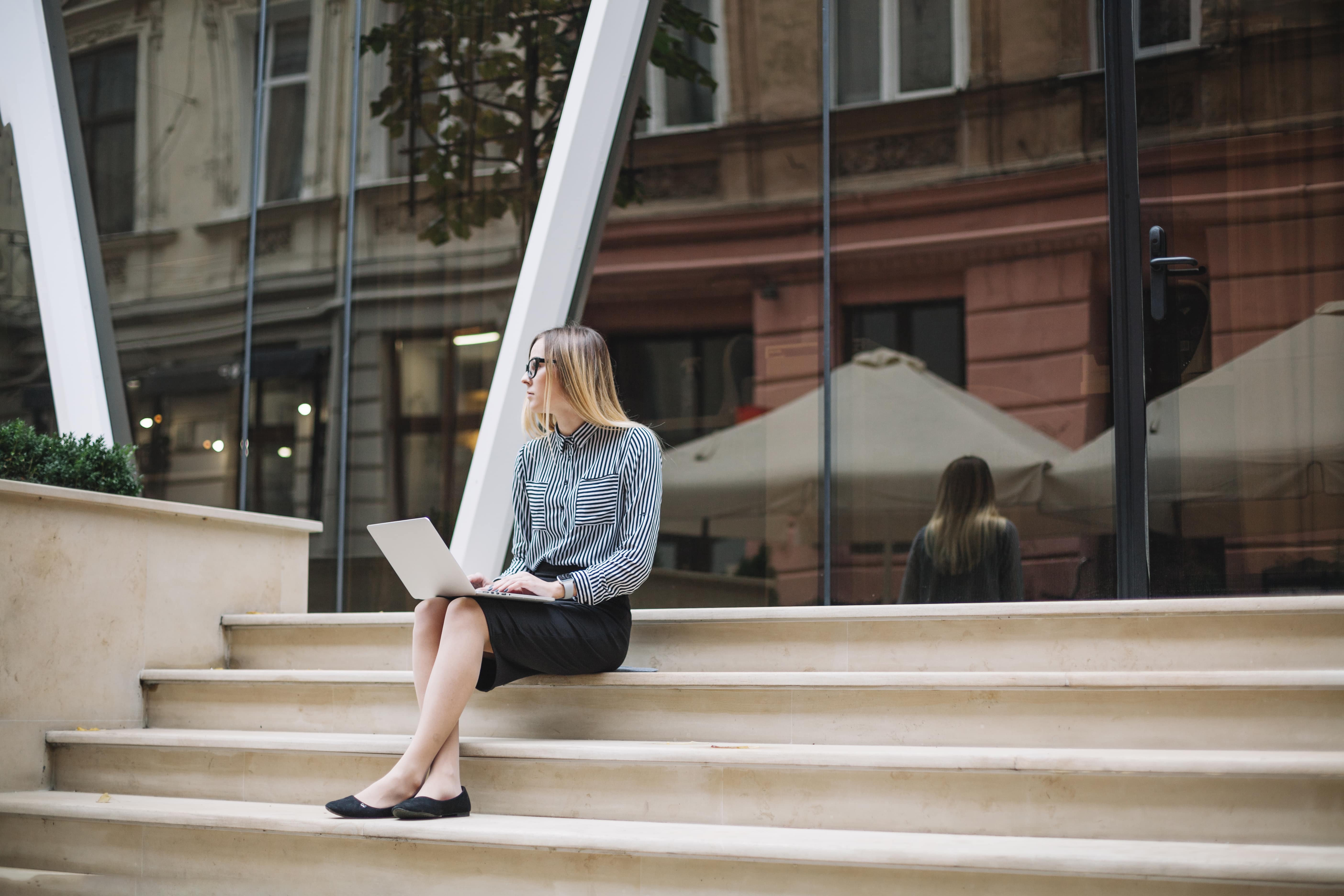 Business woman sitting on stairs working