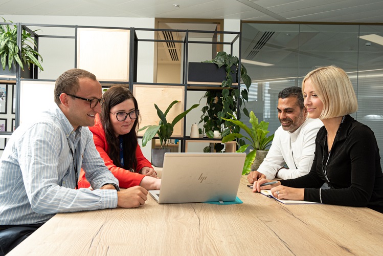 A team looking at a laptop screen together
