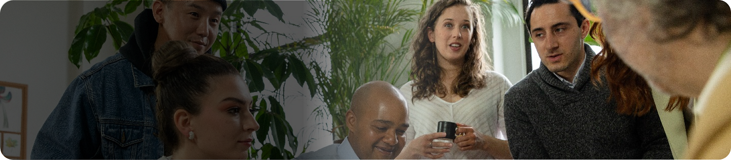 Smiling woman with earbud looking at a laptop