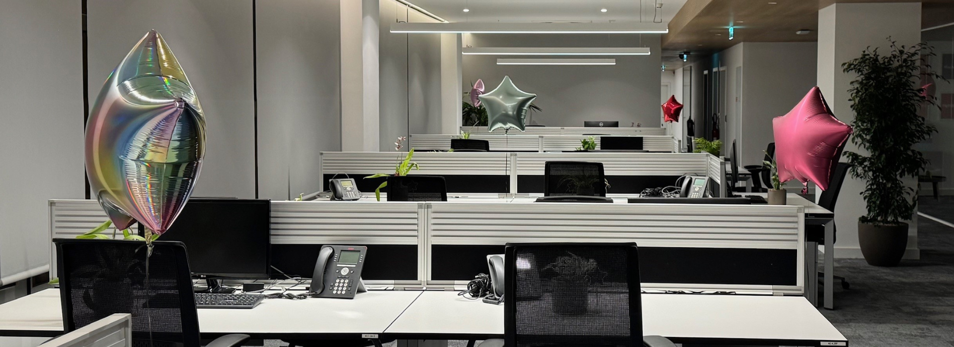 An office space featuring multiple desks and chairs arranged neatly within a well-lit room.
