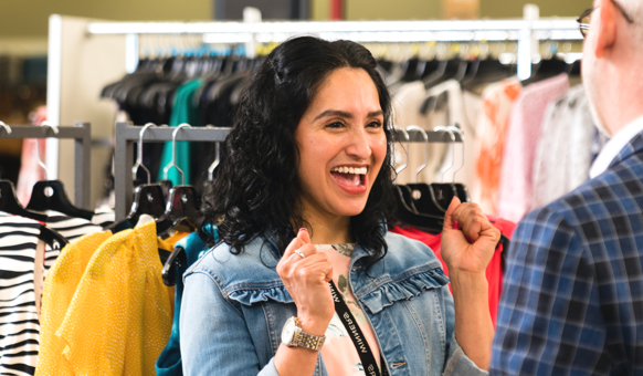 Un empleado sonriendo en el departamento de ropa