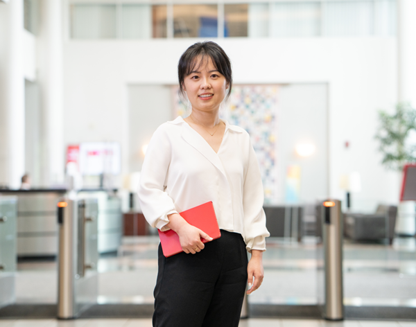 Une femme qui sourit à l’appareil photo dans la salle des serveurs. 