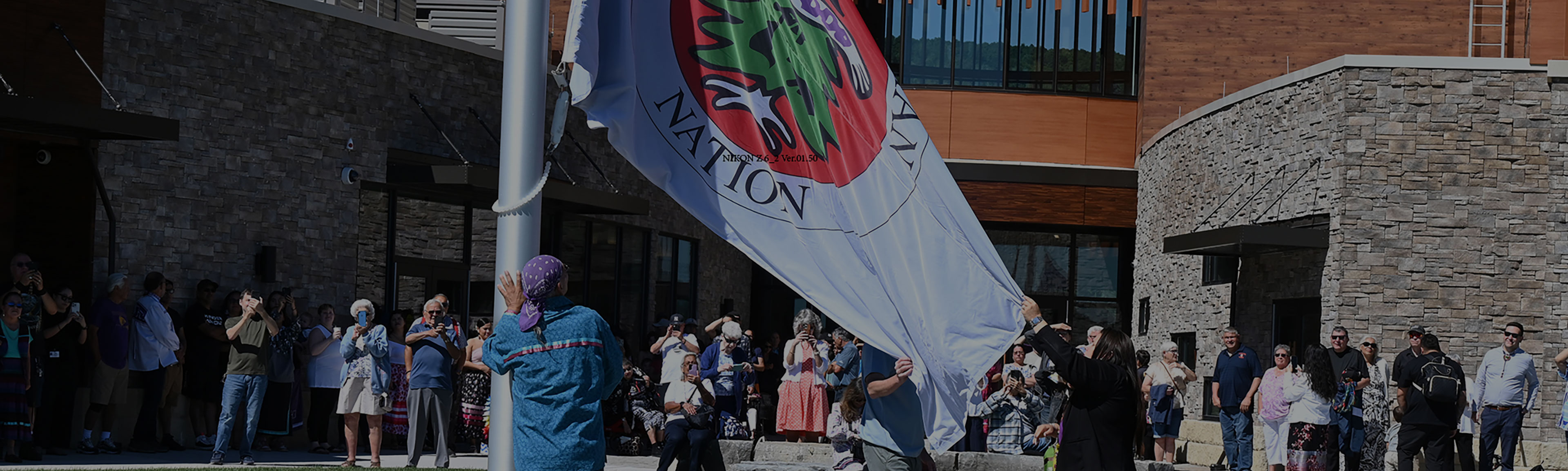 People are gathered for the raising of the Oneida Indian Nation flag. 