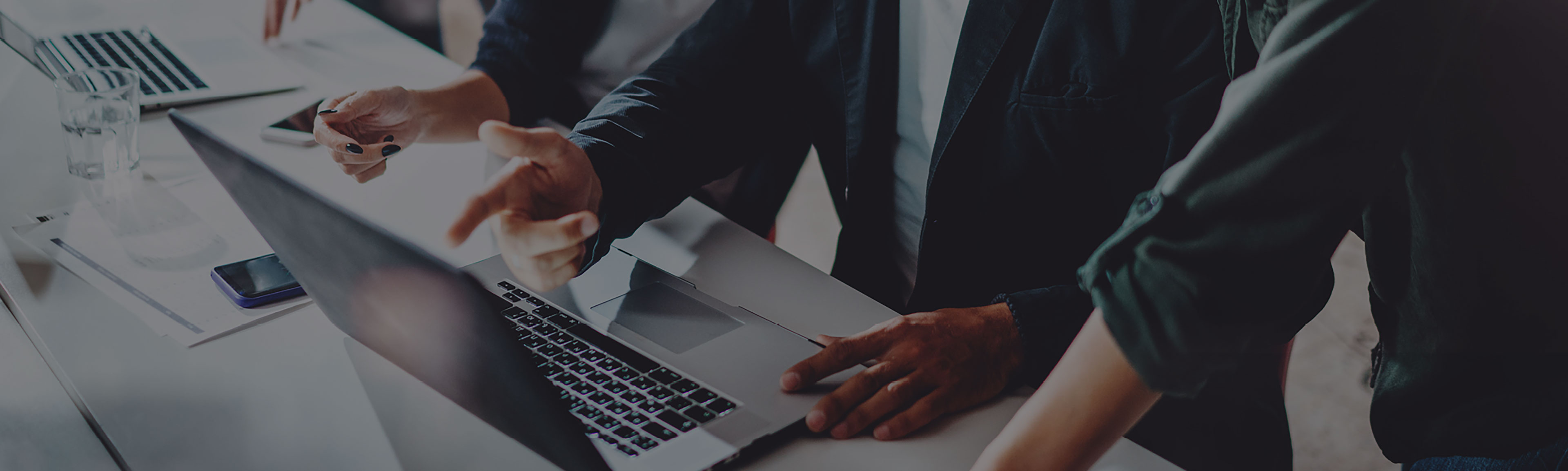 Team members are working on laptops. 