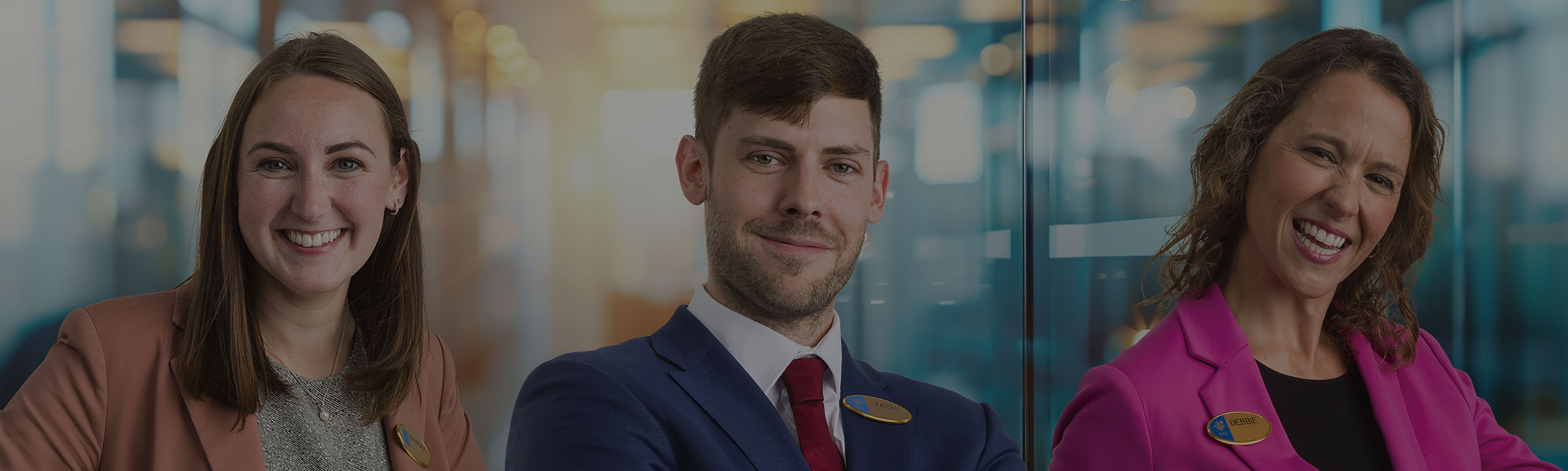 Three team members are posing and smiling for the camera. 