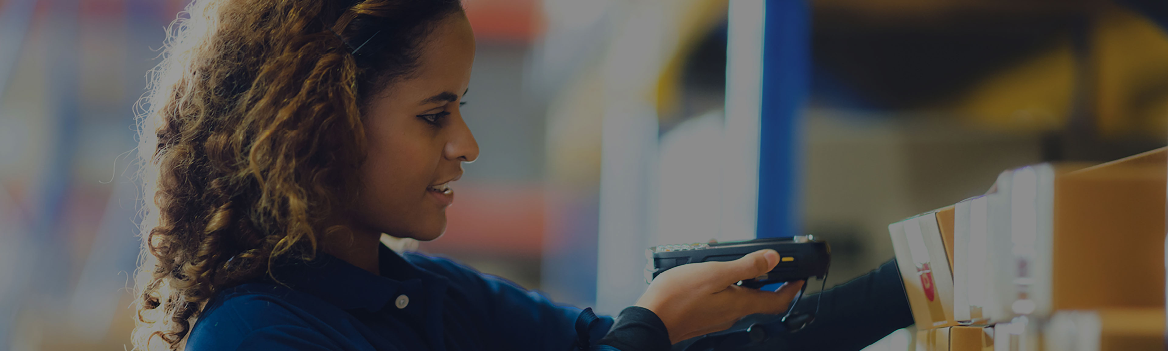 A team member is scanning and shelving items in a warehouse.