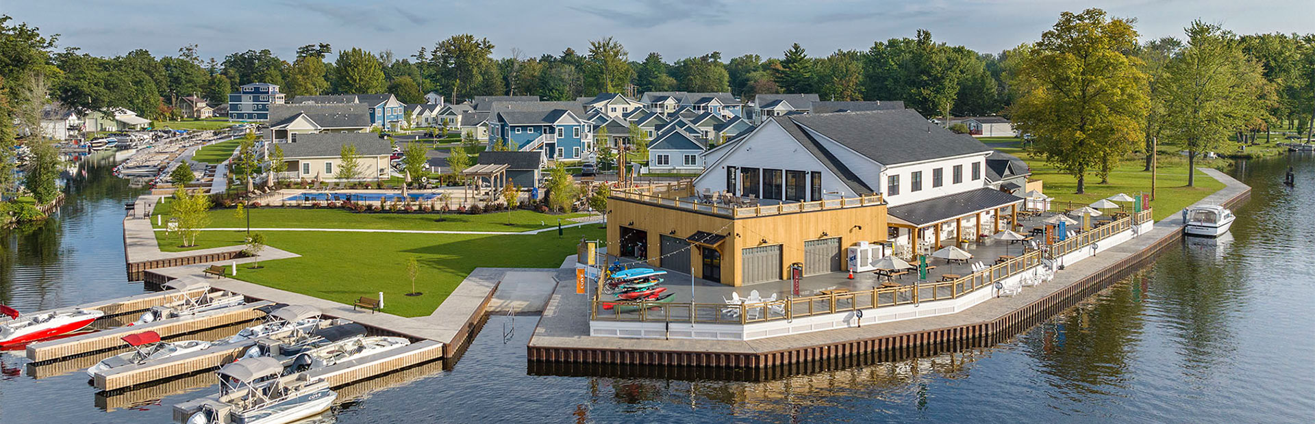 Sun hitting a boathouse and dock with rows of beautiful houses in the background. 