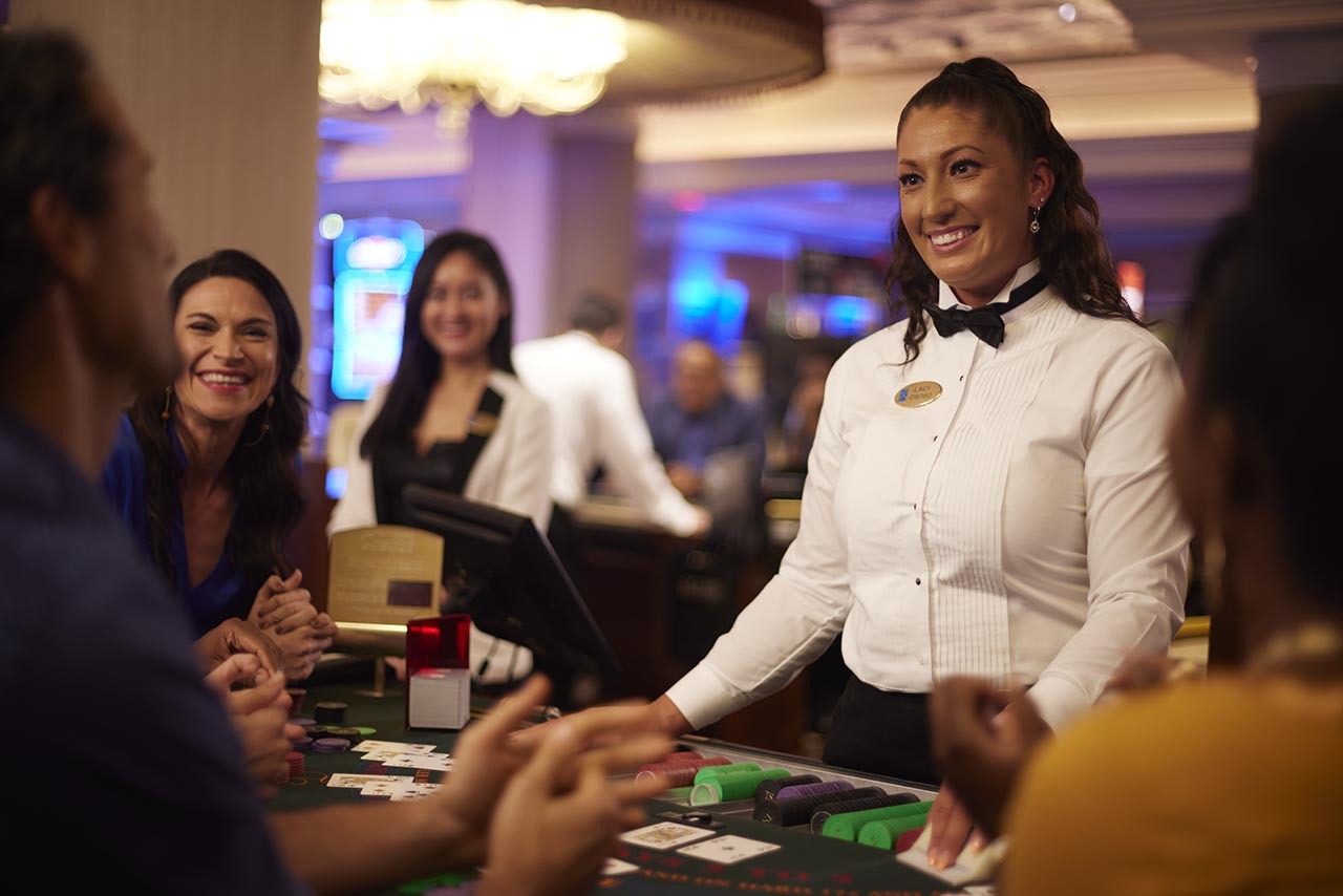 Dealer interacting with guests at the casino table. 