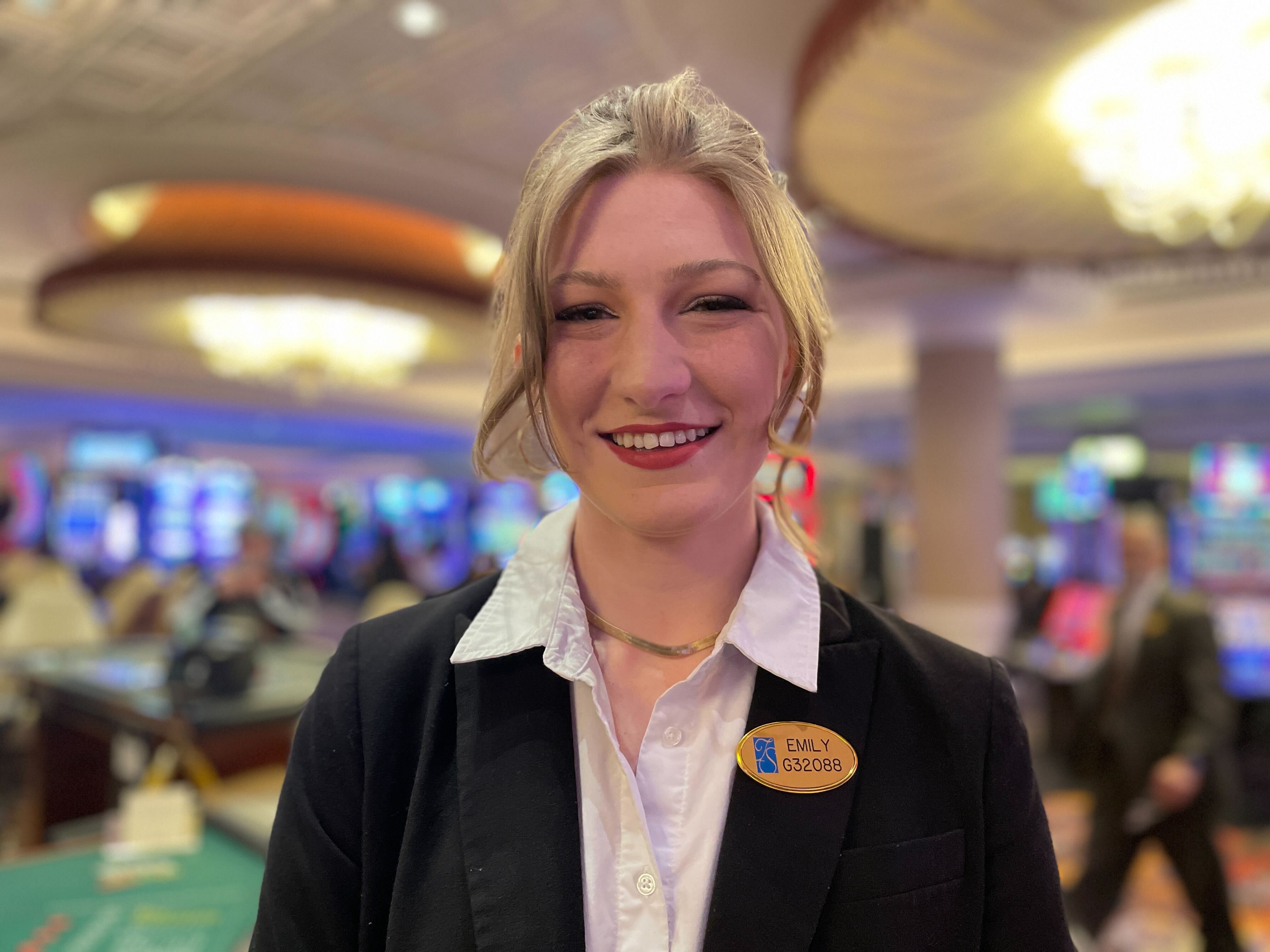 A team member smiling for the camera with the casino floor in the background. 