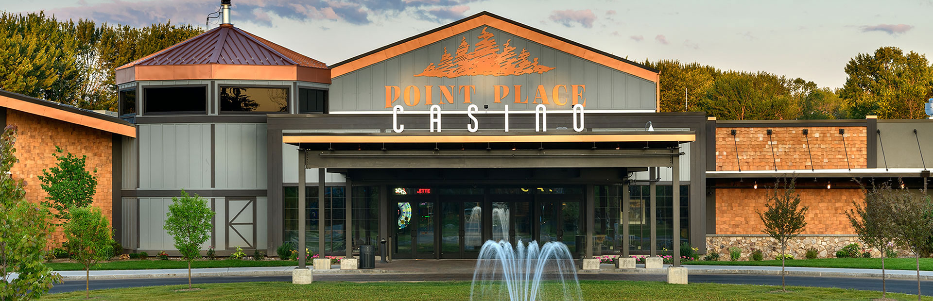 Exterior shot of the Point Place Casino entrance with a beautiful fountain flowing on the lawn. 