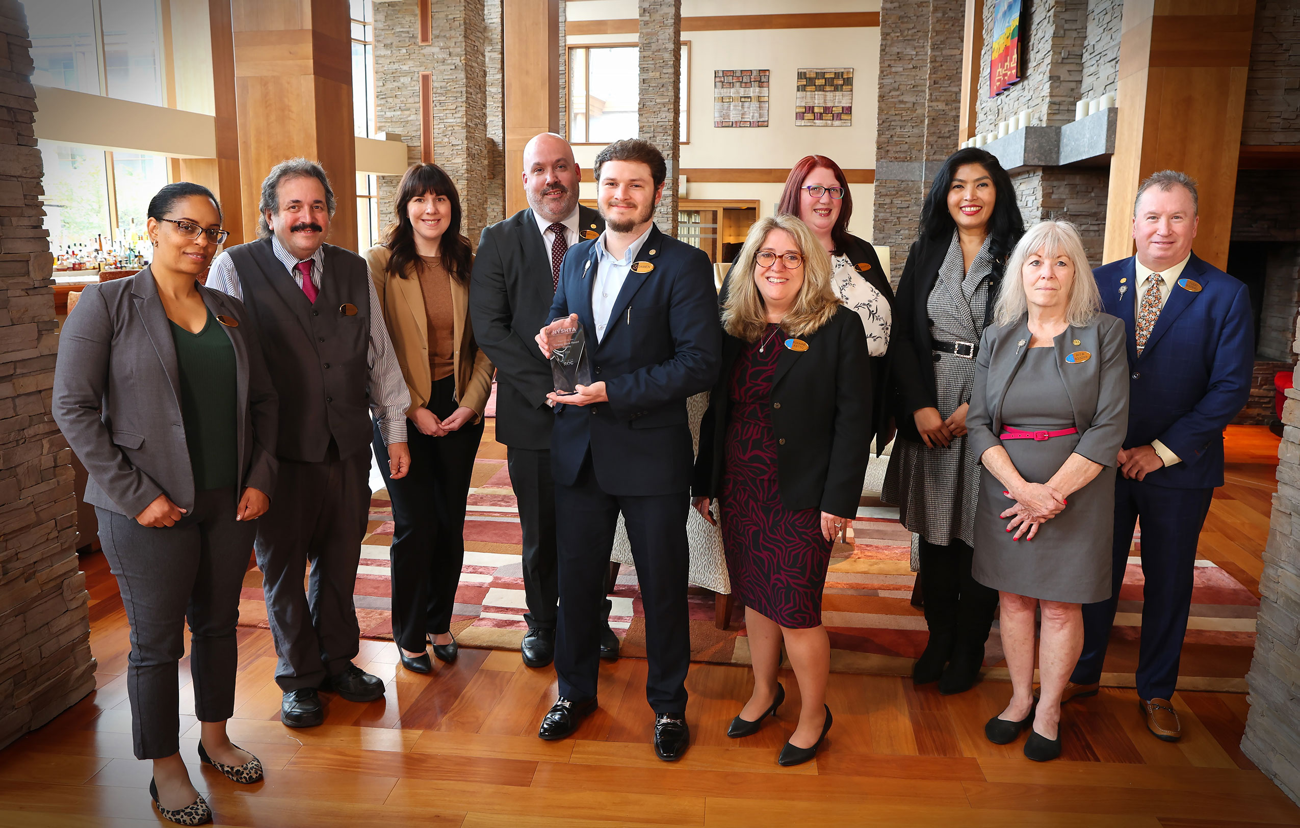 A group of team members posing with an excellence award they won. 