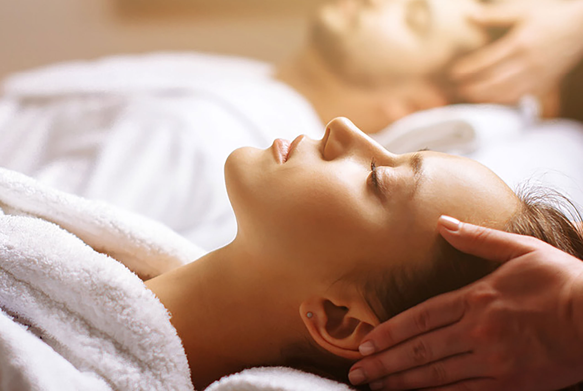 A woman relaxing while getting a head massage. 