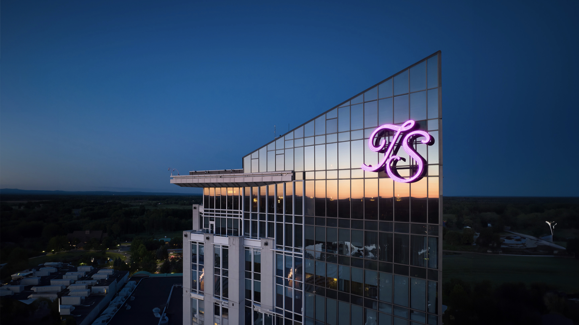 Turning Stone Resort Casino tower with a dark blue evening sky in the background.  