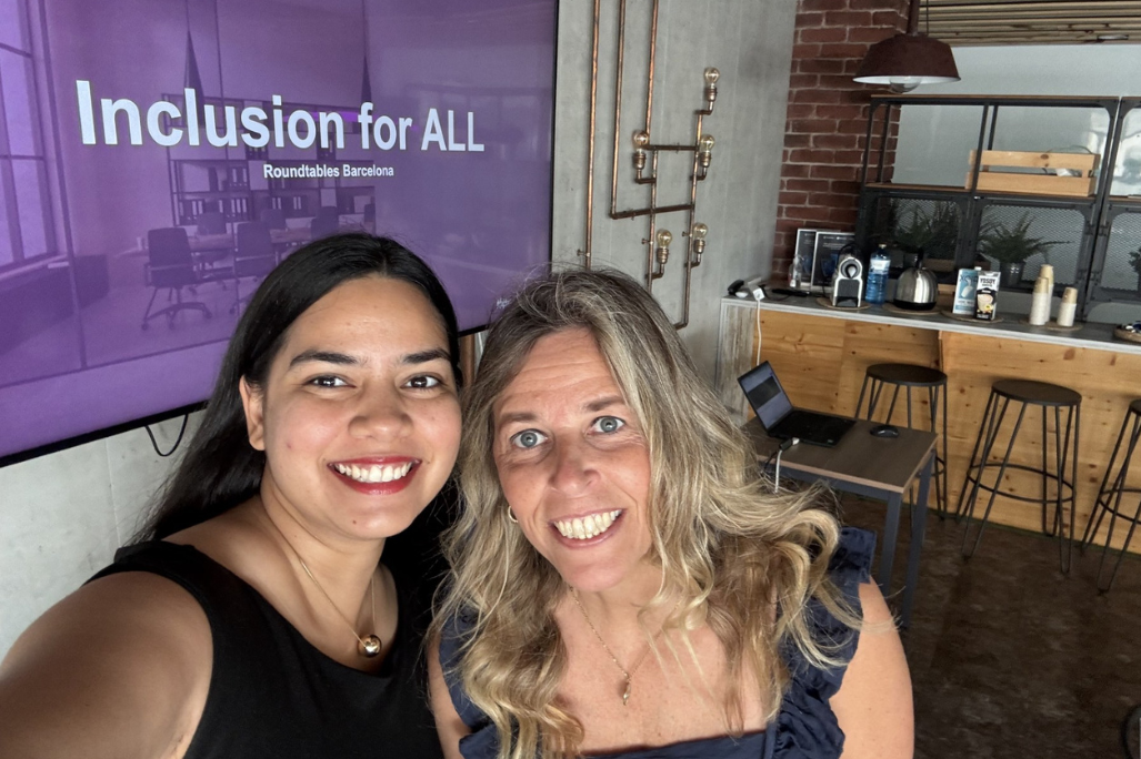 Co-workers standing in front of a presentation that says "Inclusion for ALL"