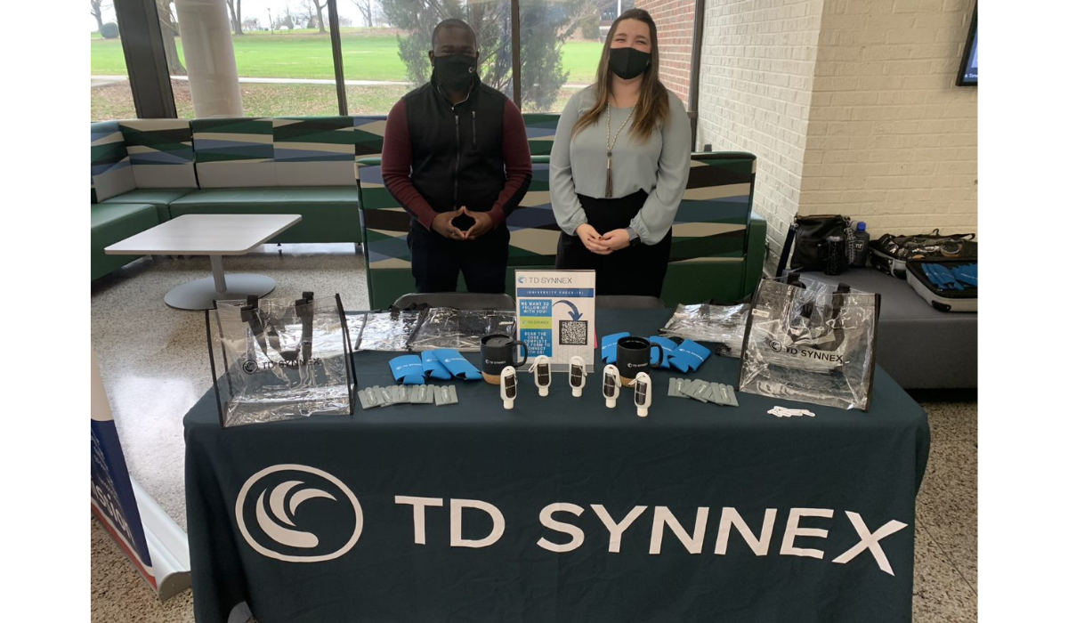 Two TD SYNNEX recruiters standing behind a table with TD SYNNEX promotional items on top.