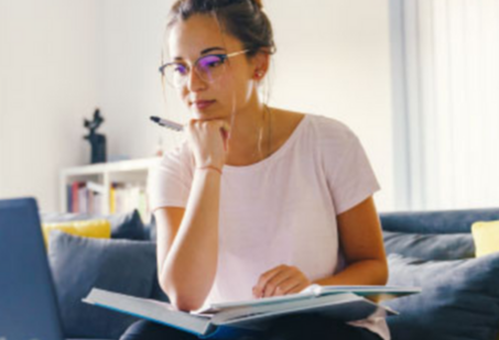 Woman sitting on couch, looking at her computer.