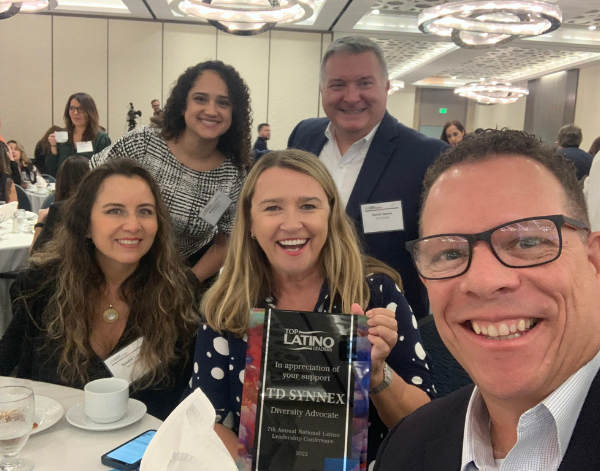 Group of 5 employees holding up an award at a banquet.